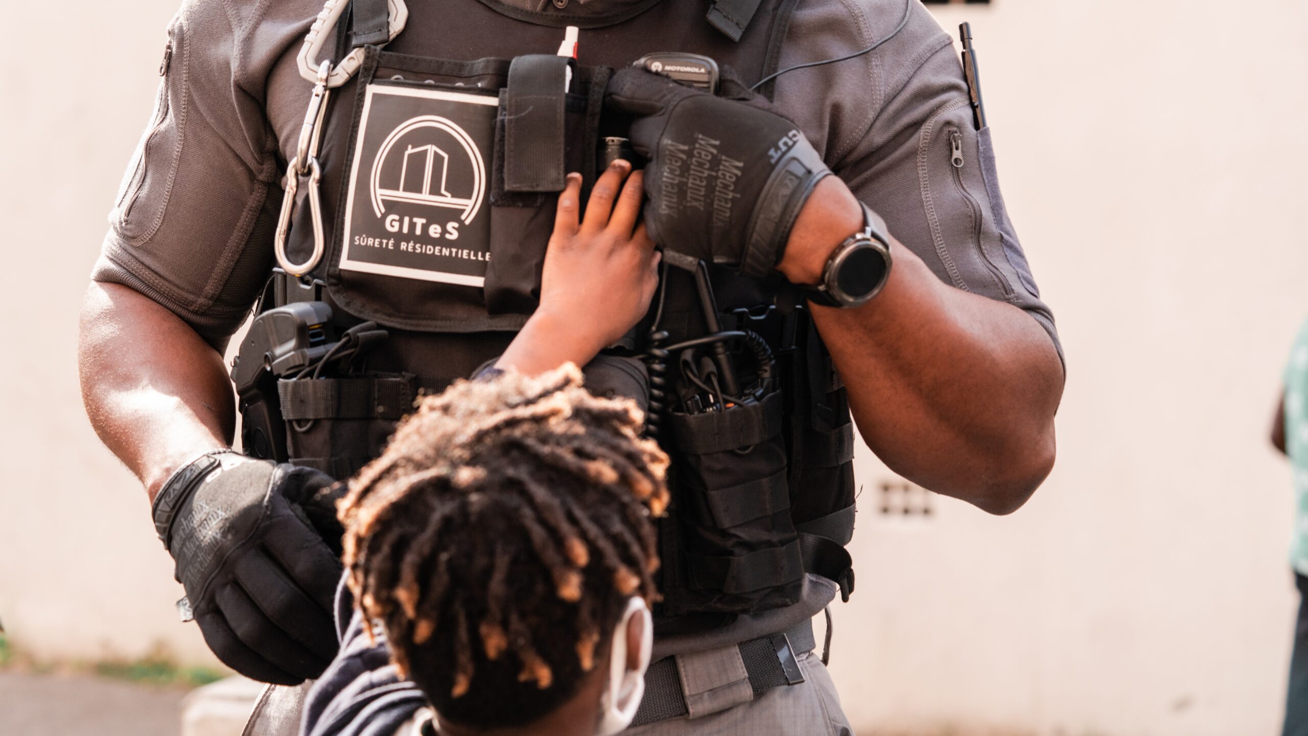 Un enfant touche le gilet d'un agent du GITeS